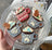 Decorative cookies shaped like mugs with snowflakes and paw designs, on a clear glass plate.