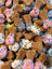 Dog treats shaped like bones with colorful sprinkles on a pile.