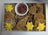 A dog treat Barkcuterie Box containing assorted natural dog treats arranged in an open box. Includes various natural dog treats such as 'crackers', 'cheese' diamonds, freeze dried strawberries and a squirrel shaped treat.