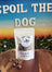 Pouch of Spoil The Dog treat on a wooden surface with a scenic background