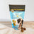 A package of Spoil the Dog brand wheat-free crunchy dog treats in peanut butter flavor, with a 200g weight indication, displayed on a wooden surface with a representation of the treat and a dog on the front.