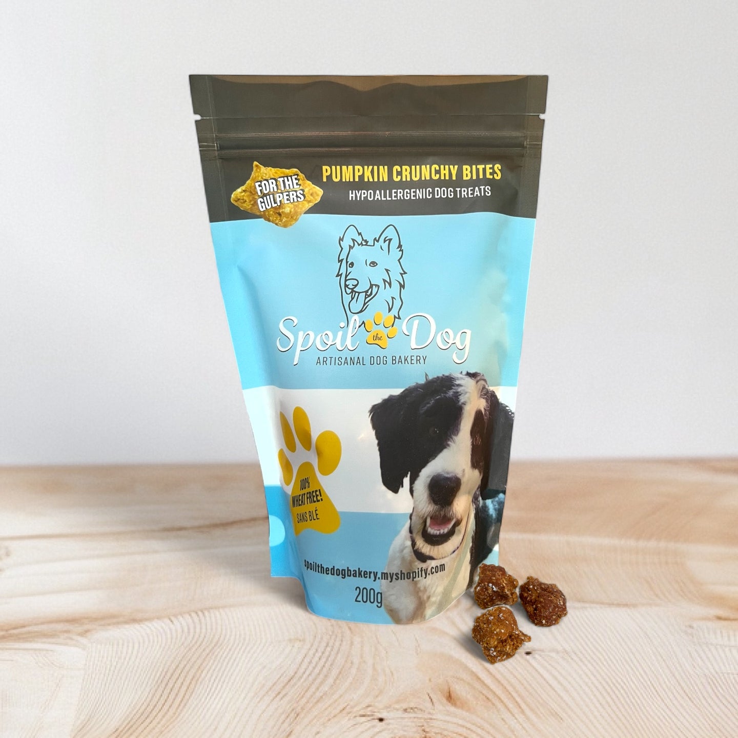 Spoil Dog pumpkin crunchy bites packaging on a wooden surface with a white background
