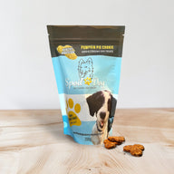A pack of Spoil the Dog brand wheat-free dog treats in Pumpkin Pie Cookie flavor. The packaging is blue with an image of a dog and the treats are visible in front of the pack.