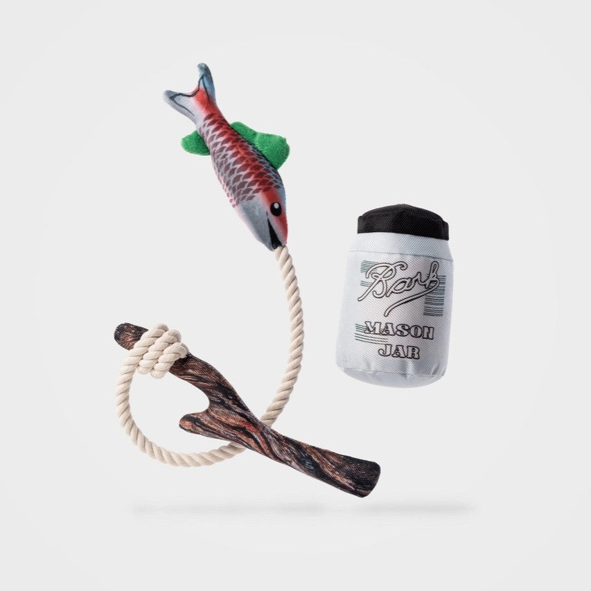Dog toy, wooden stick, and white container labeled 'Bark’ on a light gray background