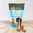 A variety pack of wheat-free dog treats with four different flavors displayed in front of a bag with a dog image and product information.