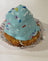 Blue dog cupcakes with sprinkles on a wooden surface.