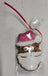 A peanut butter dog treat shaped like a Santa Claus figure, packaged in a clear plastic bag.