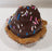 Chocolate colour dog cupcake with sprinkles on a wooden surface. Icing is made from carob.