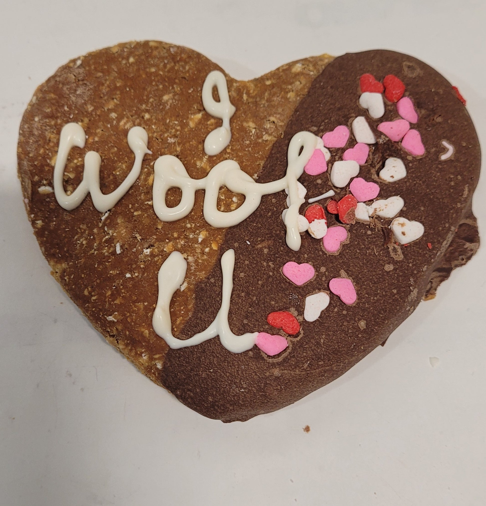 Heart shaped cookie dipped in carob, with the words "I woof u"  piped in white yogurt.