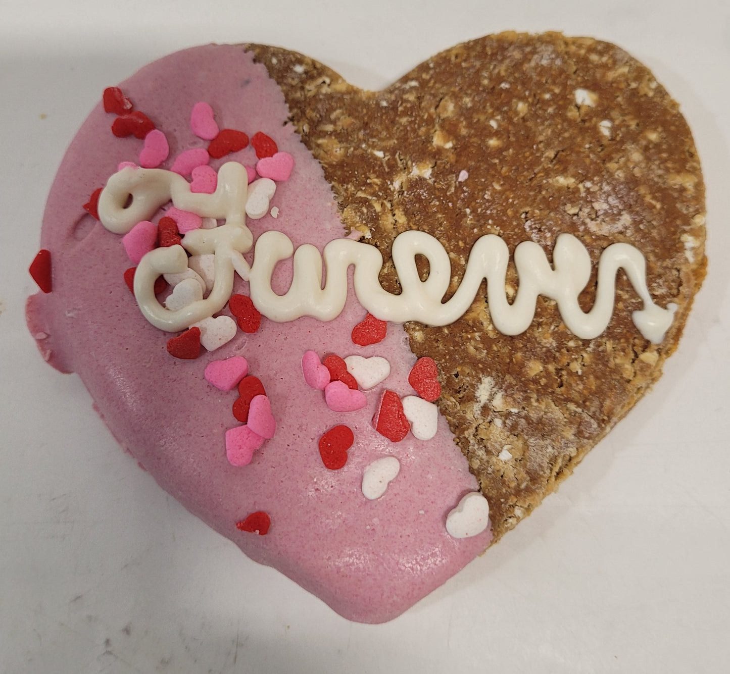 Heart shaped cookie dipped in pink yogurt, with the word "Furever" piped in white yogurt.
